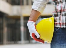 Lavoratore tiene in mano un casco di sicurezza